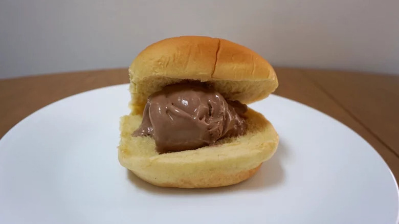A Shake Shack Ice Cream sandwich featuring two potato buns and melting ice cream in between