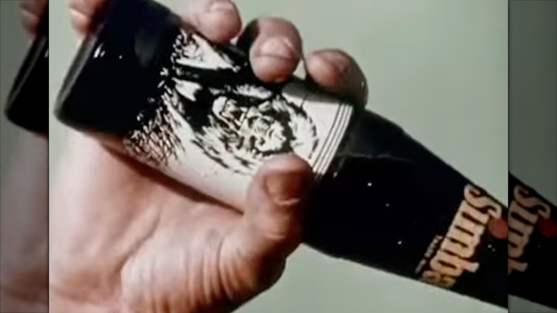 Person drinking a bottle of Simba Soda