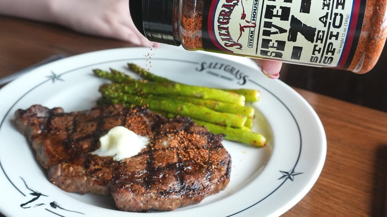 Steakhouse customer seasoning ribeye steak