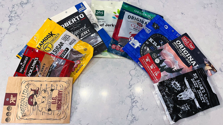 A fan of bags of beef jerky on marble table