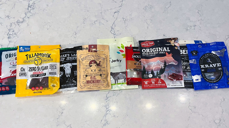 A lineup of beef jerky bags on marble table