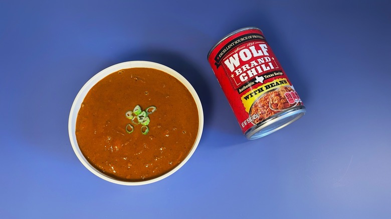 A can of Wolf Brand chili next to a bowl of chili