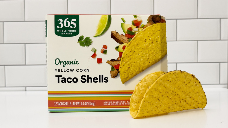 A box of 365 organic taco shells from Whole Foods, with a taco outside the box on the right side