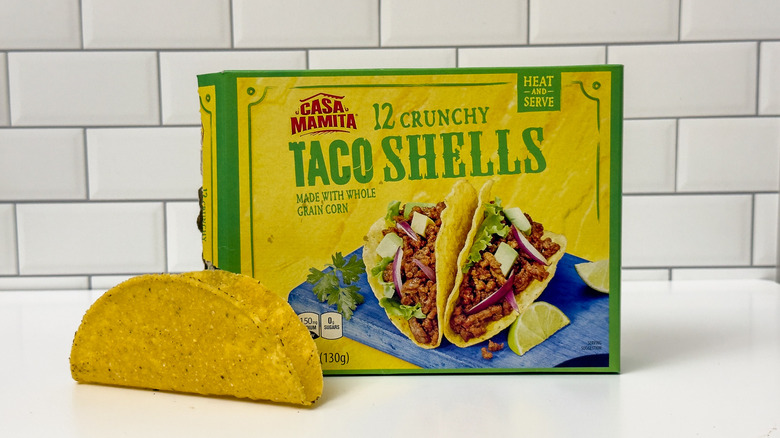 A box of Aldi's Casa Mamita crunchy taco shells, with a taco outside the box on the left side