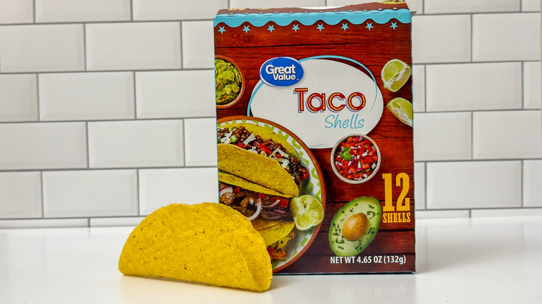 A Great Value hard taco shell box, with a shell outside the box on the left side
