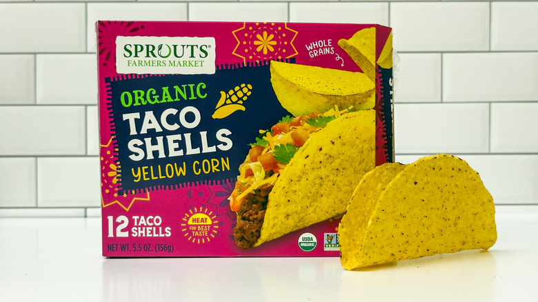 A box of organic taco shells from Sprouts Farmers Market, with a taco outside the box on the right side