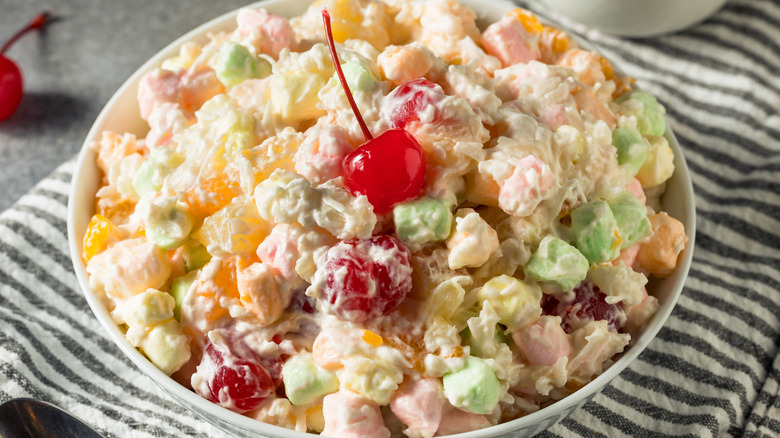 A very colorful ambrosia salad with a cherry on top