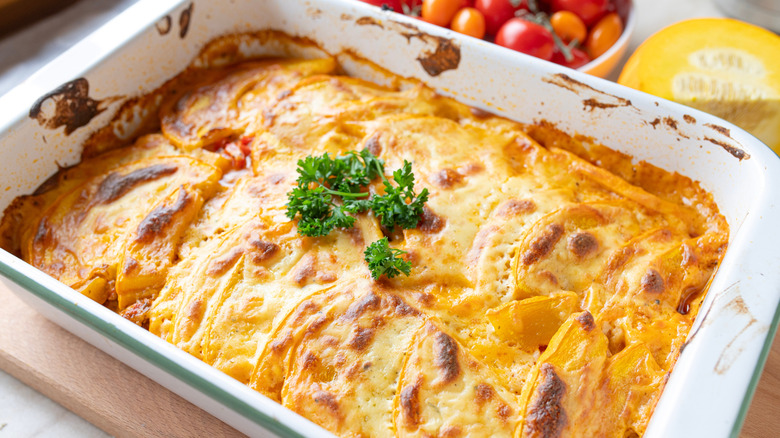 A cheesy baked casserole in a white casserole dish