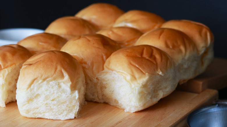 take and bake dinner rolls on a wooden cutting board