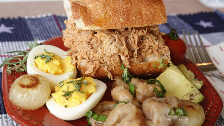 Plate with deviled eggs and barbecue pulled pork sandwich