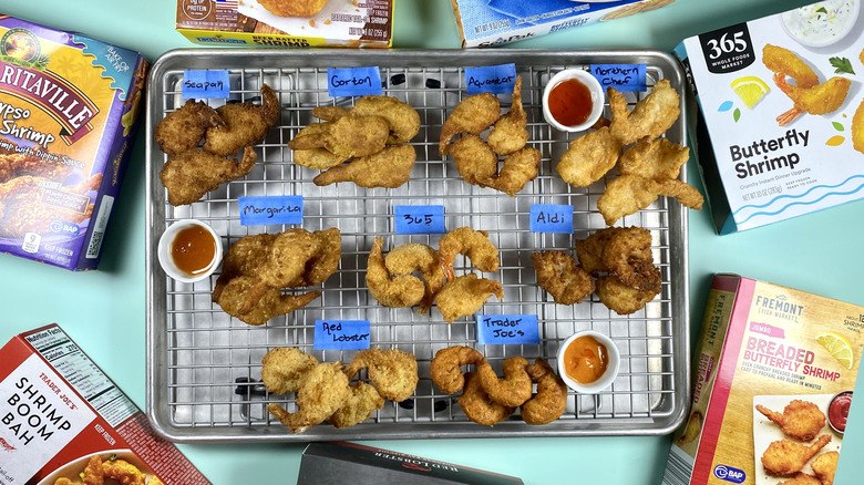 Assorted brands of fried shrimp on a cooling rack, surrounded by the original packaging