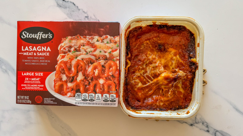 Lasagna with packaging on marble surface