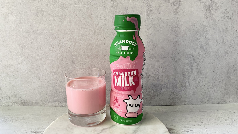 Shamrock Farms 2% Reduced Fat Strawberry Milk in the original packaging and in a glass on a white marble coaster