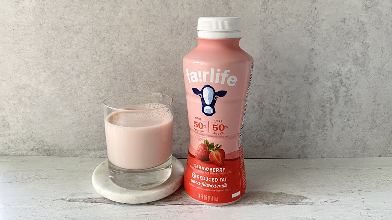 fairlife Strawberry 2% Reduced Fat Ultra-Filtered Milk in the original packaging and in a glass on a white marble coaster