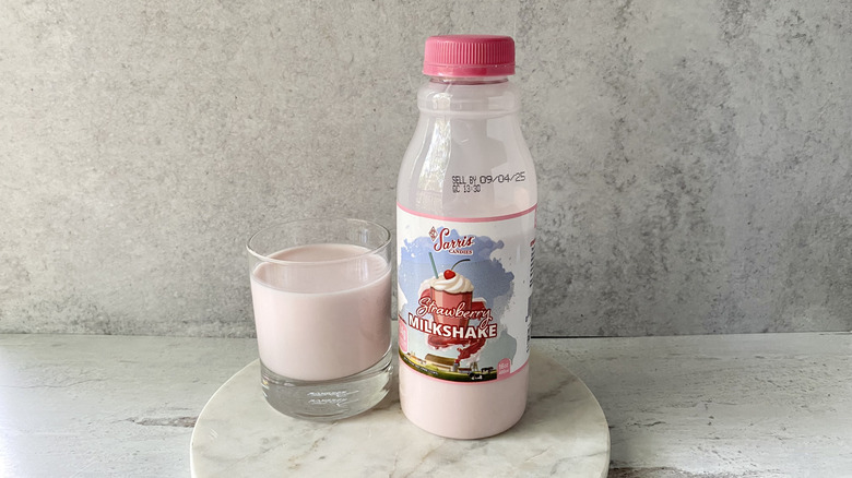 Schneider's Dairy Sarris Candies Strawberry Milkshake in the original packaging and in a glass on a white marble coaster