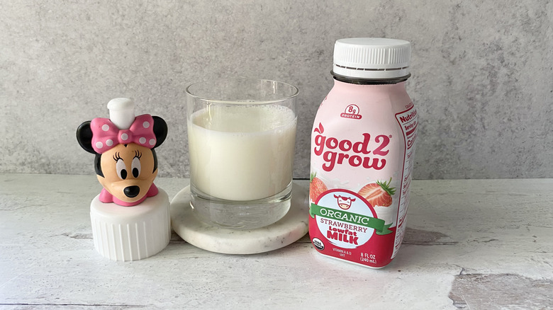 good2grow Organic Strawberry Low-Fat Milk in the original packaging and in a glass on a white marble coaster