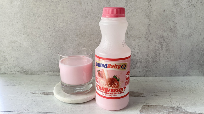 United Dairy Strawberry Flavored Whole Milk in the original packaging and in a glass on a white marble coaster
