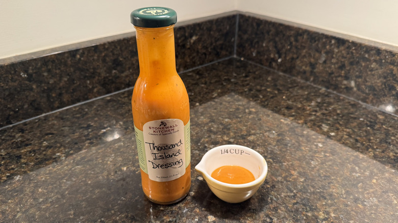 Bottle and small bowl of Stonewall Kitchen Thousand Island Dressing on black countertop