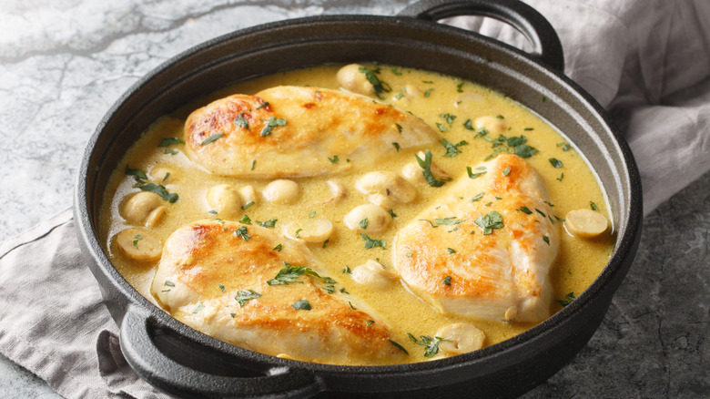 Chicken in a cast iron pan sauce with herbs and lemon