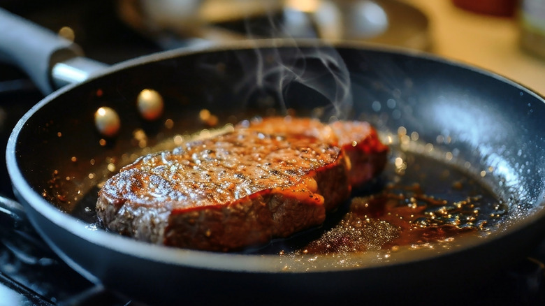 A steak searing in a pan