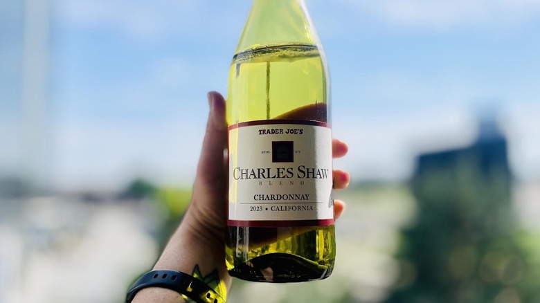Someone holding a bottle of Charles Shaw Chardonnay