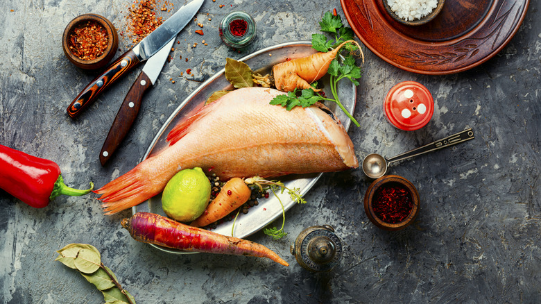 a dressed red snapper with various veggies and seasonings
