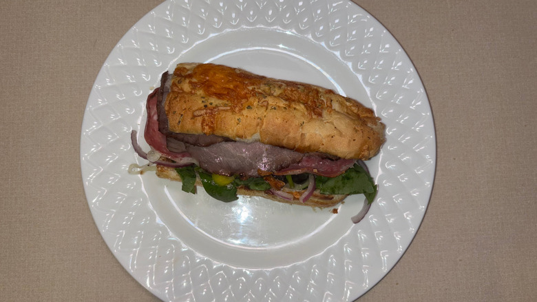 A sub on Italian herbs and cheese bread with a variety of meats and vegetables