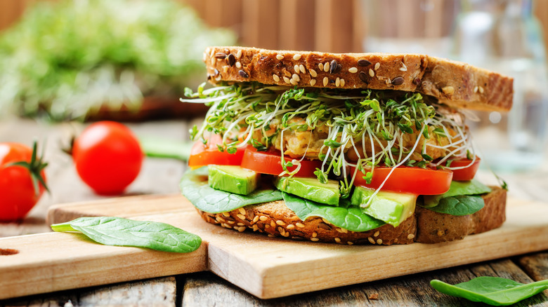 Vegetable sandwich with pea shoots, tomato, avocado, and spinach