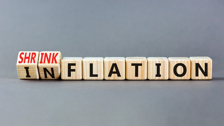 A set of blocks with the first two turning to say "shrinkflation" instead of "inflation"