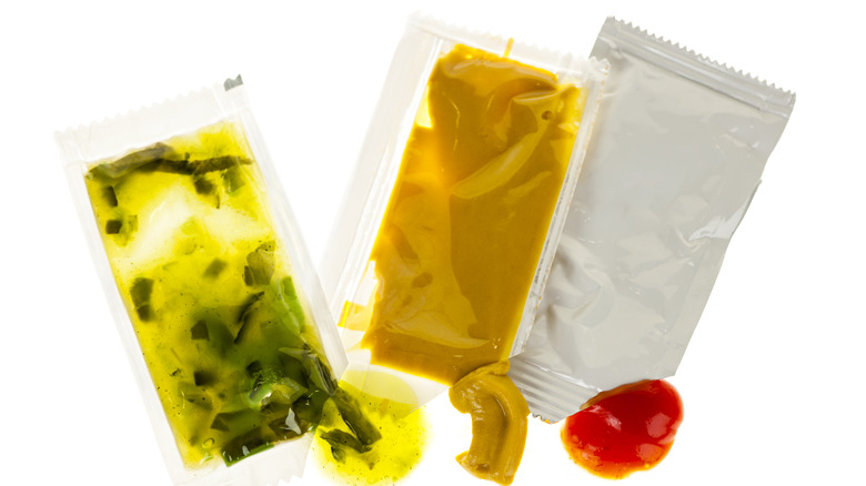 A packet of relish, mustard, and ketchup on a white background