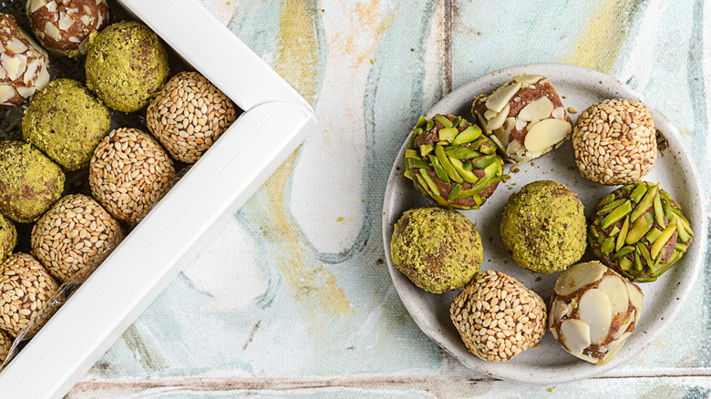 several pistachio balls on a white plate on a pastel background
