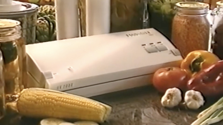 1990s FoodSaver model on a kitchen countertop surrounded by veggies in an informercial