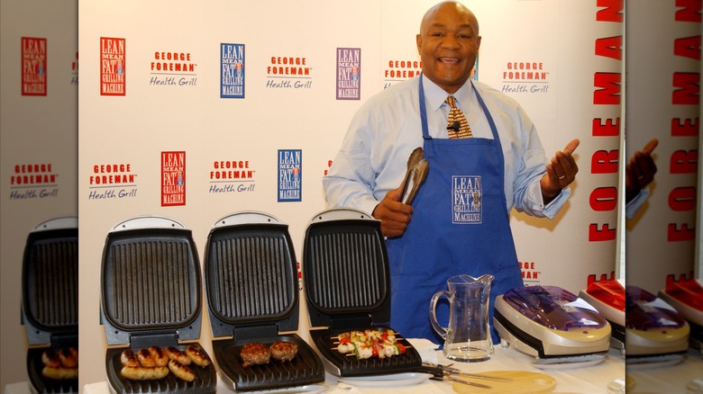 George Foreman, wearing an apron, selling his George Foreman grills
