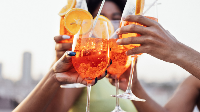 group of people toasting with Aperol spritzes