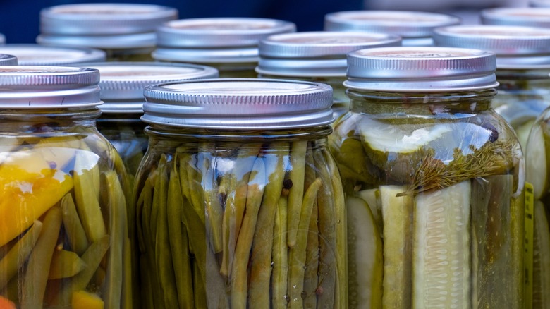 Various glass pickling jars filled with different vegetables and brines.