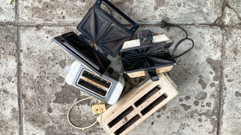 Broken kitchen appliances clustered together, overhead view.