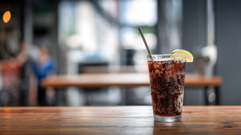 Iced cola in glass with lime garnish