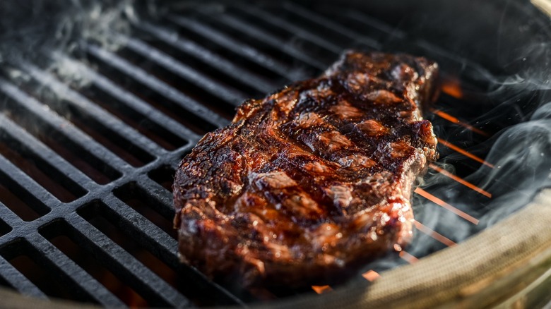 Charred steak on a flame grill