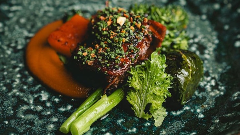 A person holding a duck dish at Damiana in Valle de Guadalupe