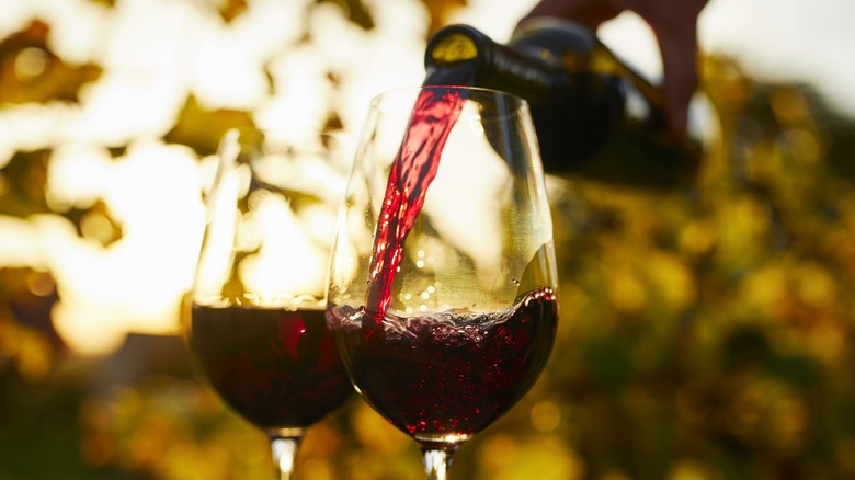 Red wine pouring into glasses