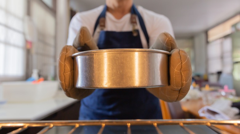 baker taking cake from oven
