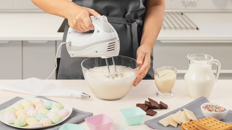 baker hand mixing milk