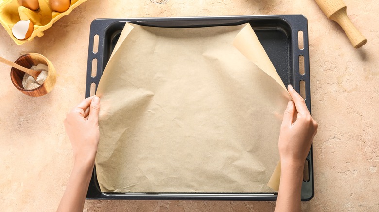 hands laying paper on tray