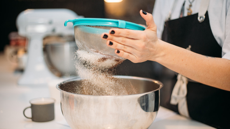 baker sifting flour with sieve