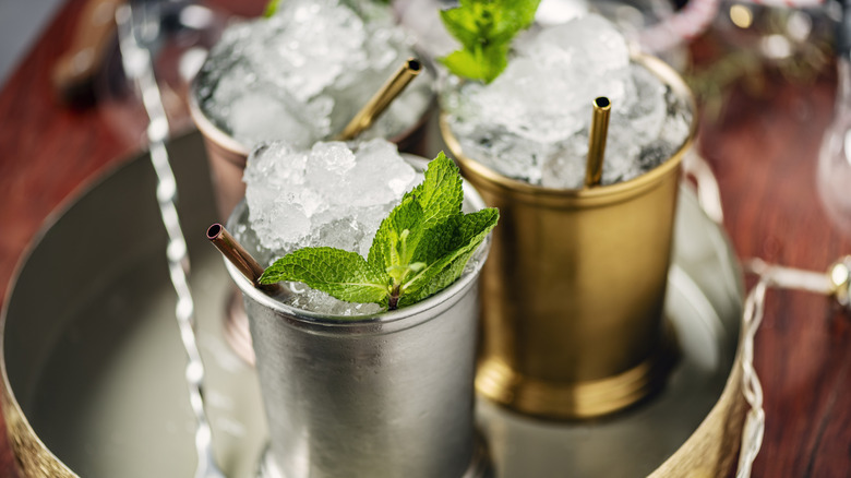 Mint juleps in metal cups on a tray