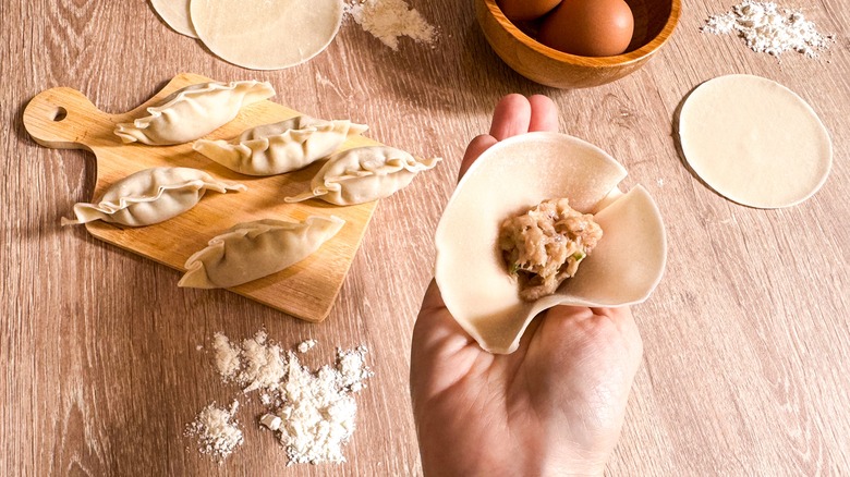 Hand holding unsealed dumpling