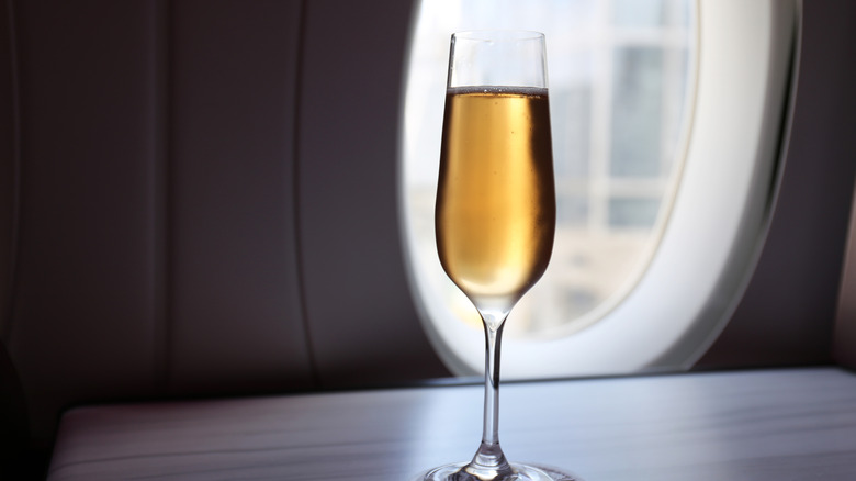 Champagne glass near airplane window