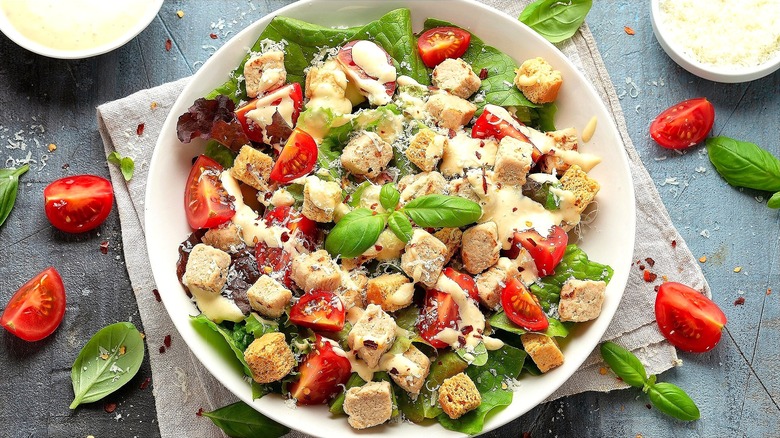 Caesar salad with sliced cherry tomatoes, chunks of chicken, and croutons