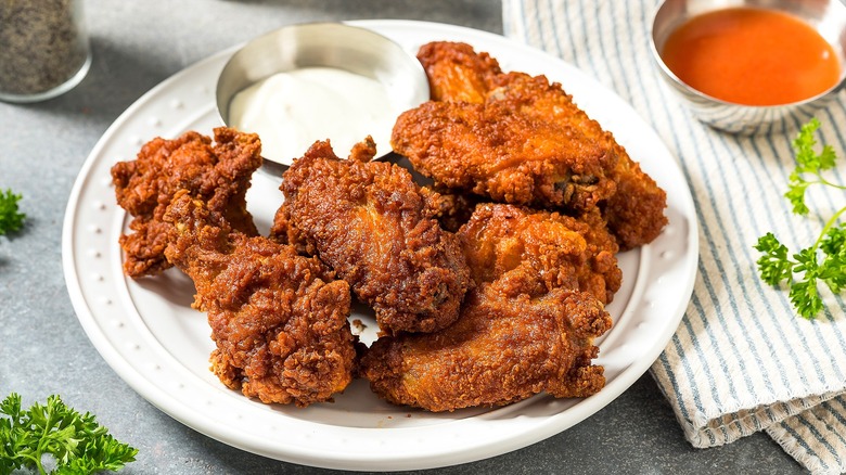 Buffalo-fried chicken with a side of ranch dressing on a white plate