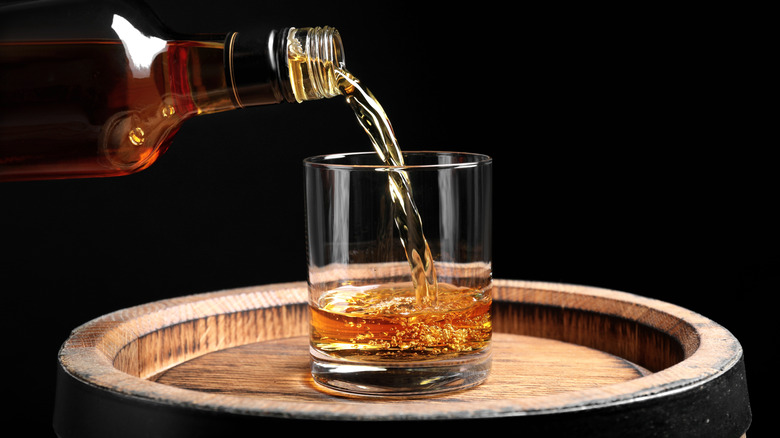 pouring whiskey from a bottle into glass
